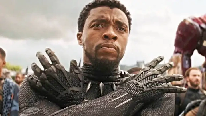 Chadwick Boseman as Black Panther performing Wakanda salute in iconic Marvel movie scene.